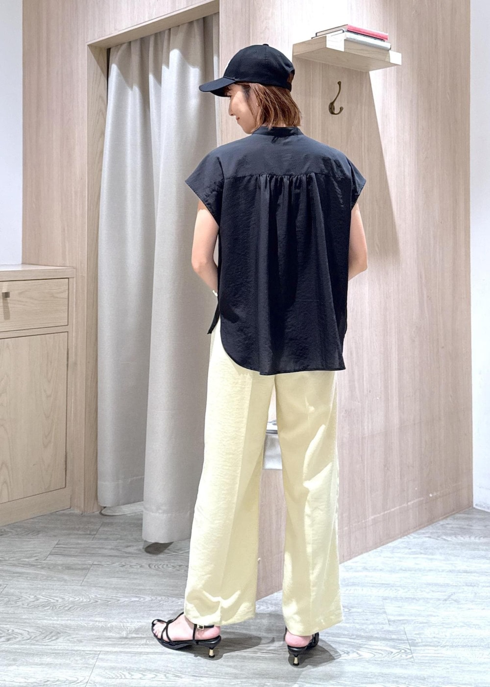 ブラック系のサンダル、イエロー系のスラックス、ブラック系のシャツ/ブラウスを着用したレディースの夏コーディネートの4枚目の写真