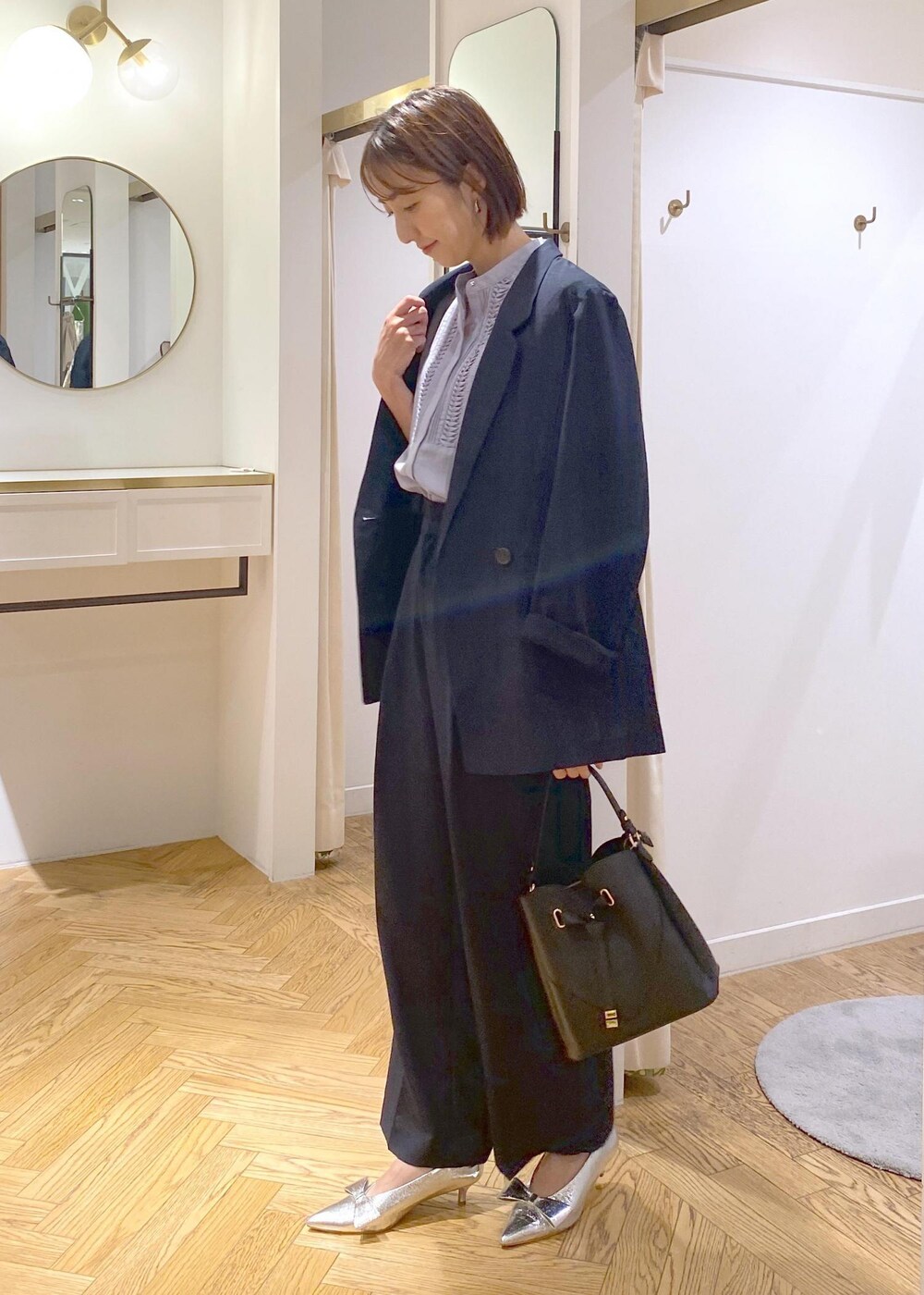 シルバー系のパンプス、ブルー系のスラックス、ブルー系のテーラードジャケットを着用したレディースの夏コーディネートの3枚目の写真