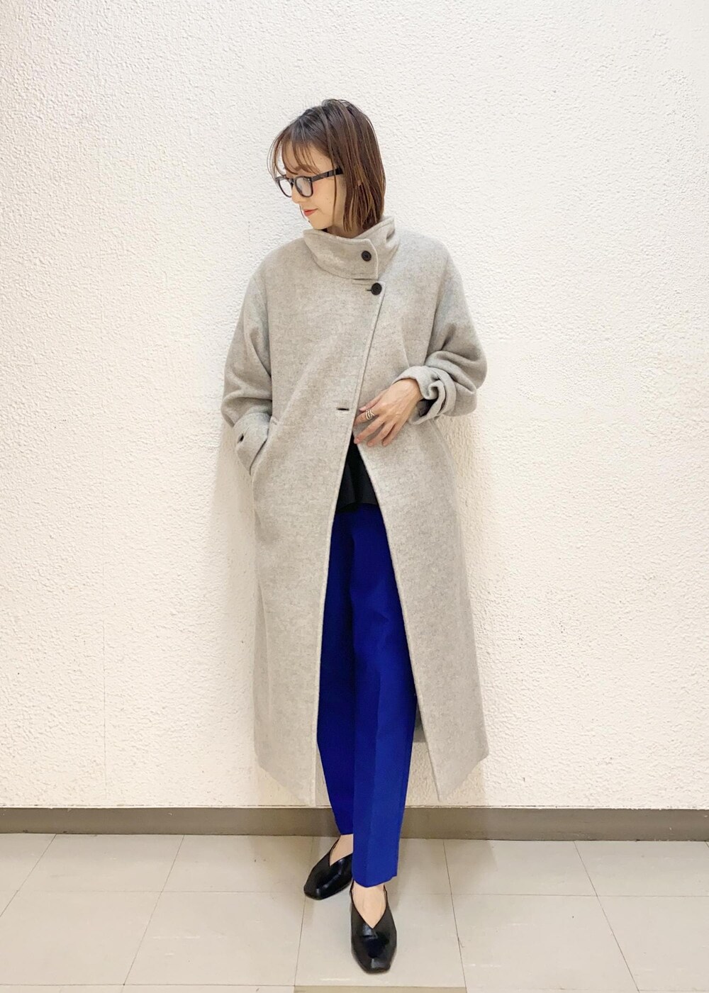 グレー系のその他アウター、ブルー系のスラックス、ブラック系のニット/セーターを着用したレディースの冬コーディネートの2枚目の写真
