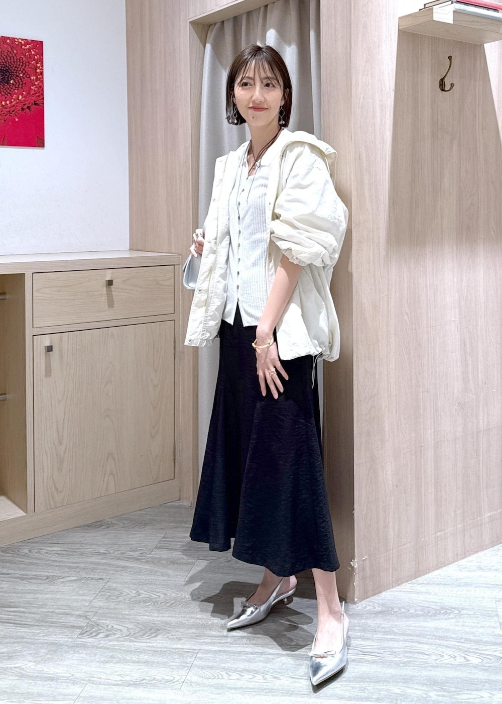 シルバー系のパンプス、ブラック系のスカート、ホワイト系のカーディガン/ボレロを着用したレディースの春コーディネートの3枚目の写真