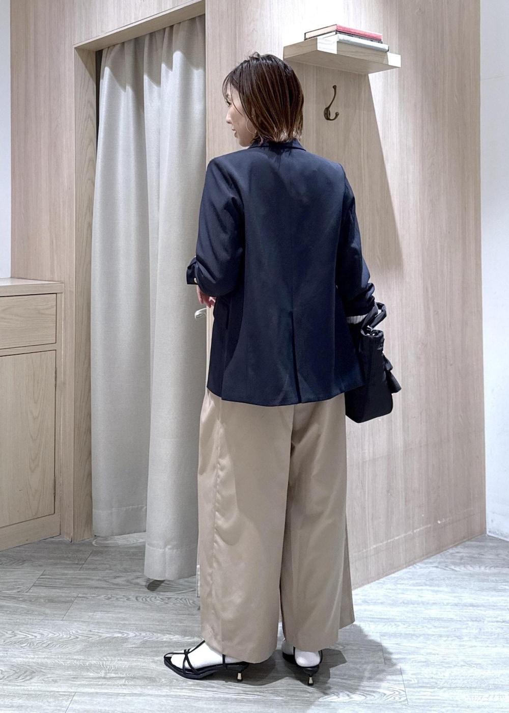 ブルー系のテーラードジャケット、ブラック系のトートバッグ、ホワイト系のカーディガン/ボレロを着用したレディースの冬コーディネートの3枚目の写真