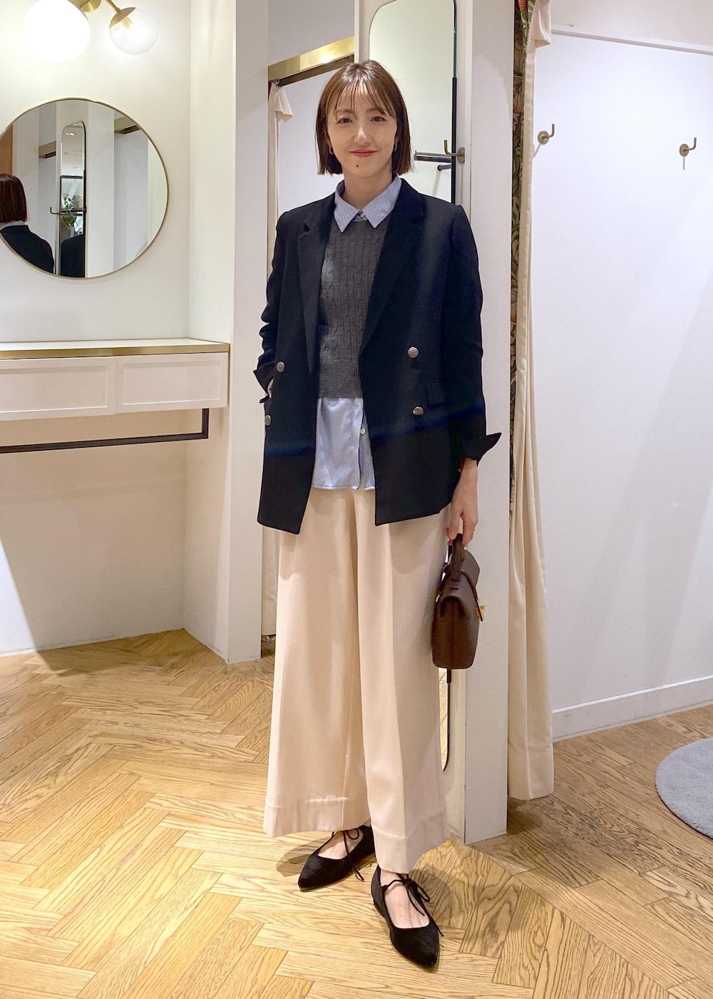 ブラウン系のショルダーバッグ、ブラック系のテーラードジャケット、ブルー系のシャツ/ブラウスを着用したレディースの冬コーディネートの5枚目の写真