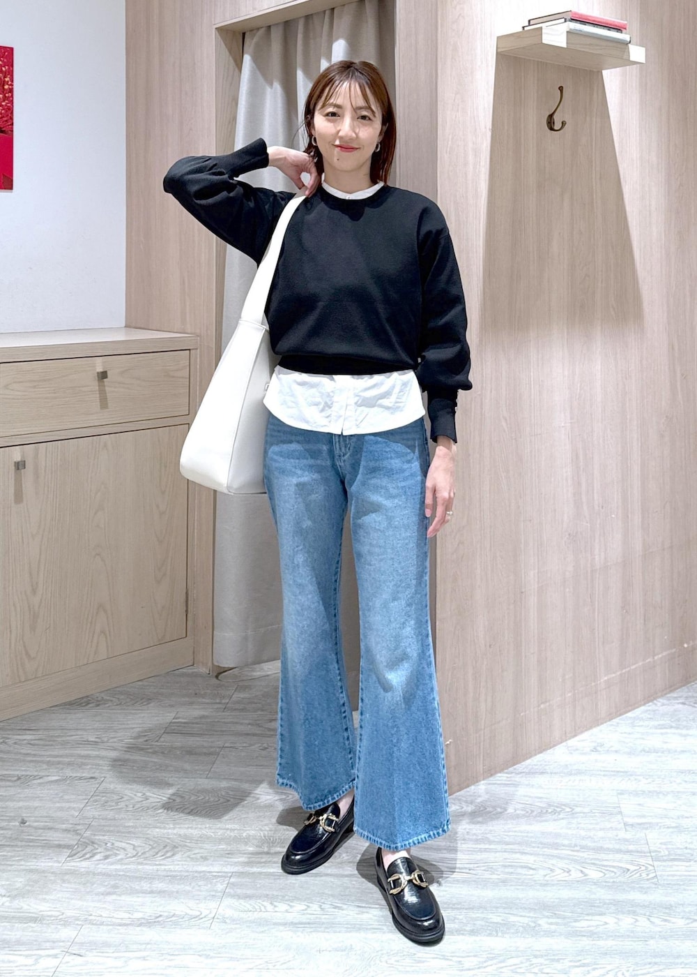 ブラック系のローファー、ホワイト系のシャツ/ブラウス、ブラック系のニット/セーターを着用したレディースの春コーディネートの2枚目の写真