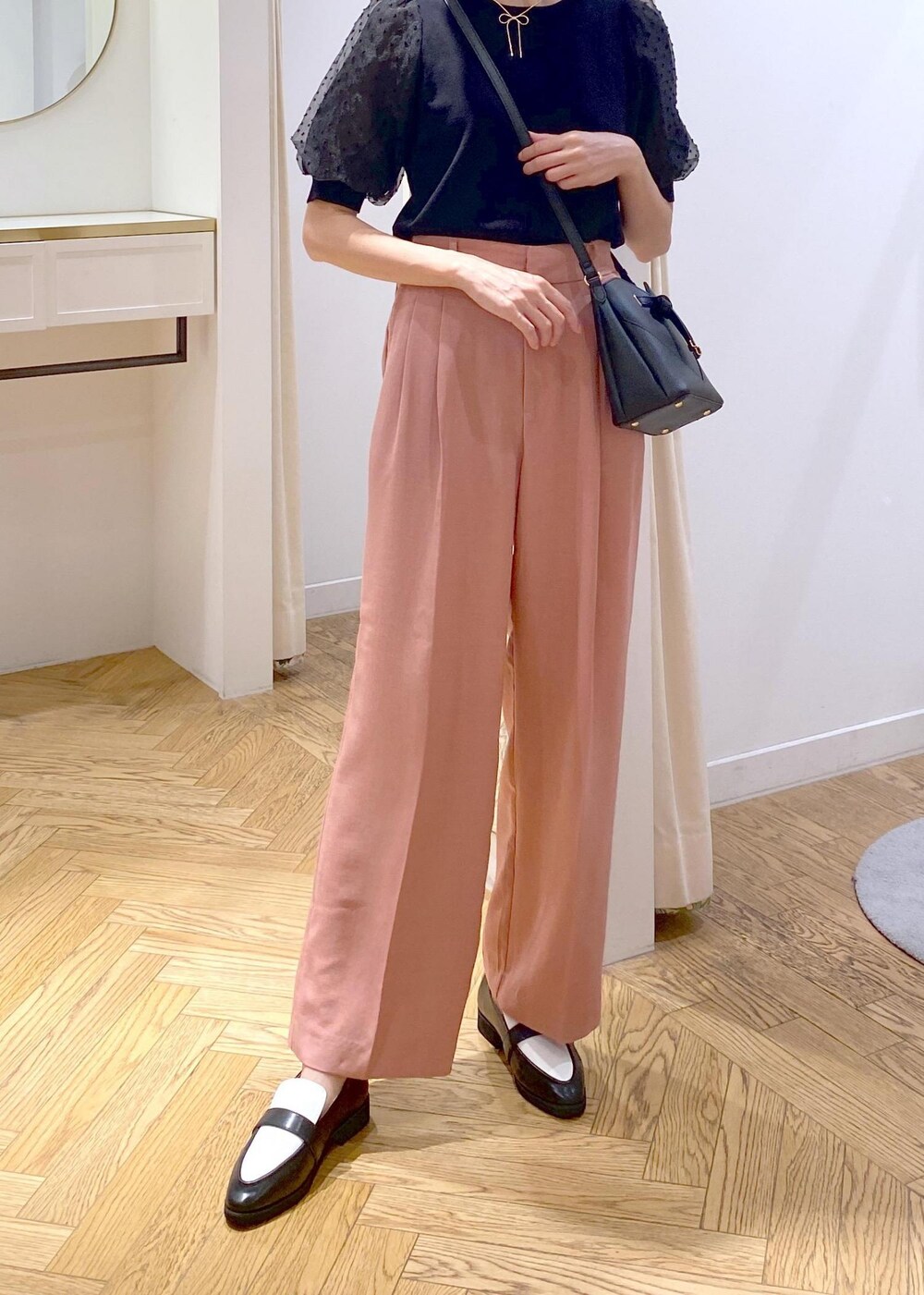 ブラック系のローファー、ブラック系のニット/セーター、ピンク系のスラックスを着用したレディースの夏コーディネートの4枚目の写真