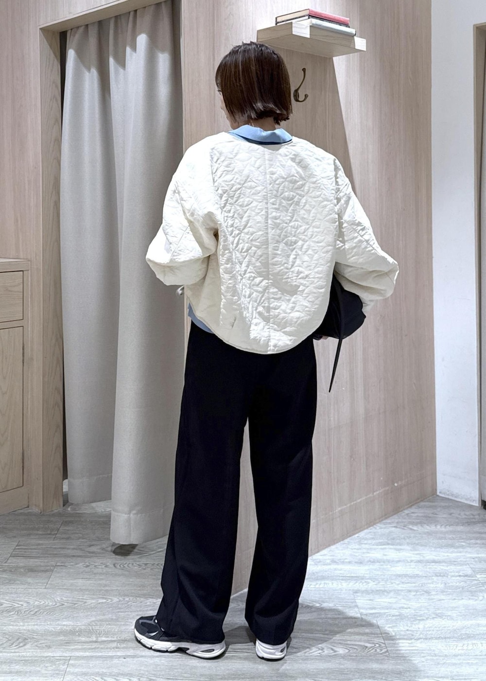 ブラック系のスラックス、ブラック系のショルダーバッグ、ブルー系のカーディガン/ボレロを着用したレディースの秋コーディネートの4枚目の写真