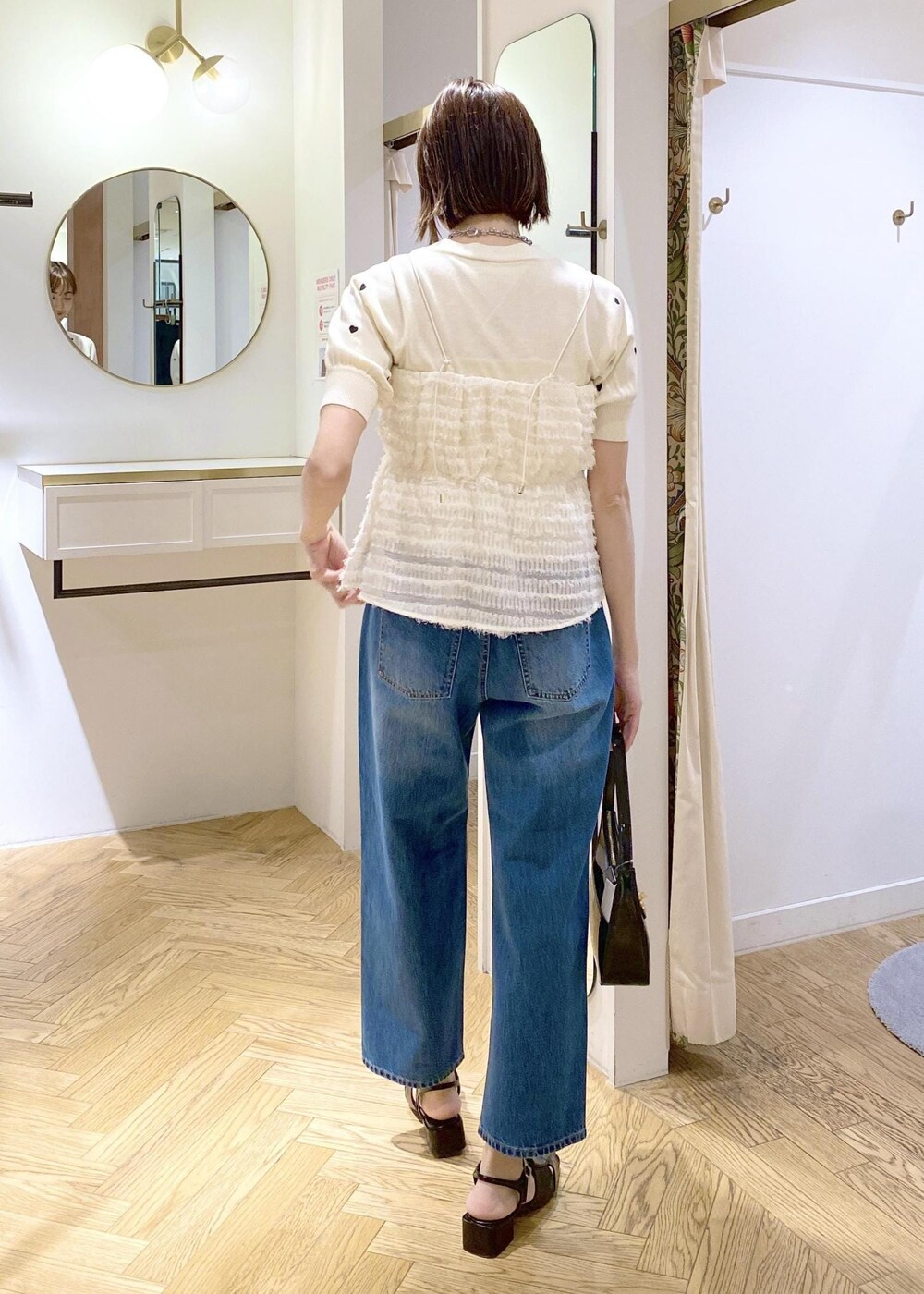 ブラック系のサンダル、ホワイト系のキャミソール、ホワイト系のニット/セーターを着用したレディースの春コーディネートの3枚目の写真