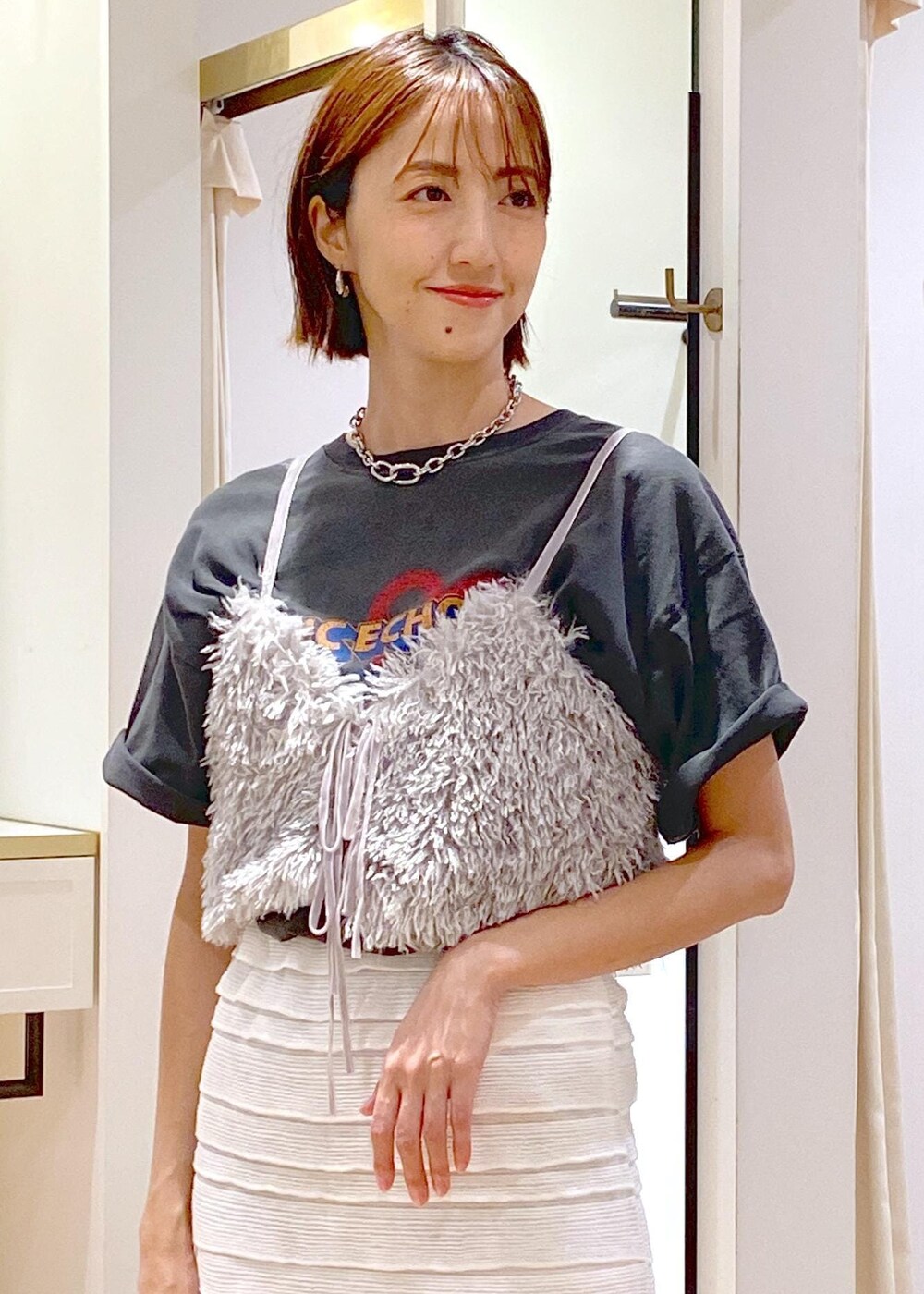 ホワイト系のスカート、シルバー系のショルダーバッグ、グレー系のキャミソールを着用したレディースの夏コーディネートの6枚目の写真