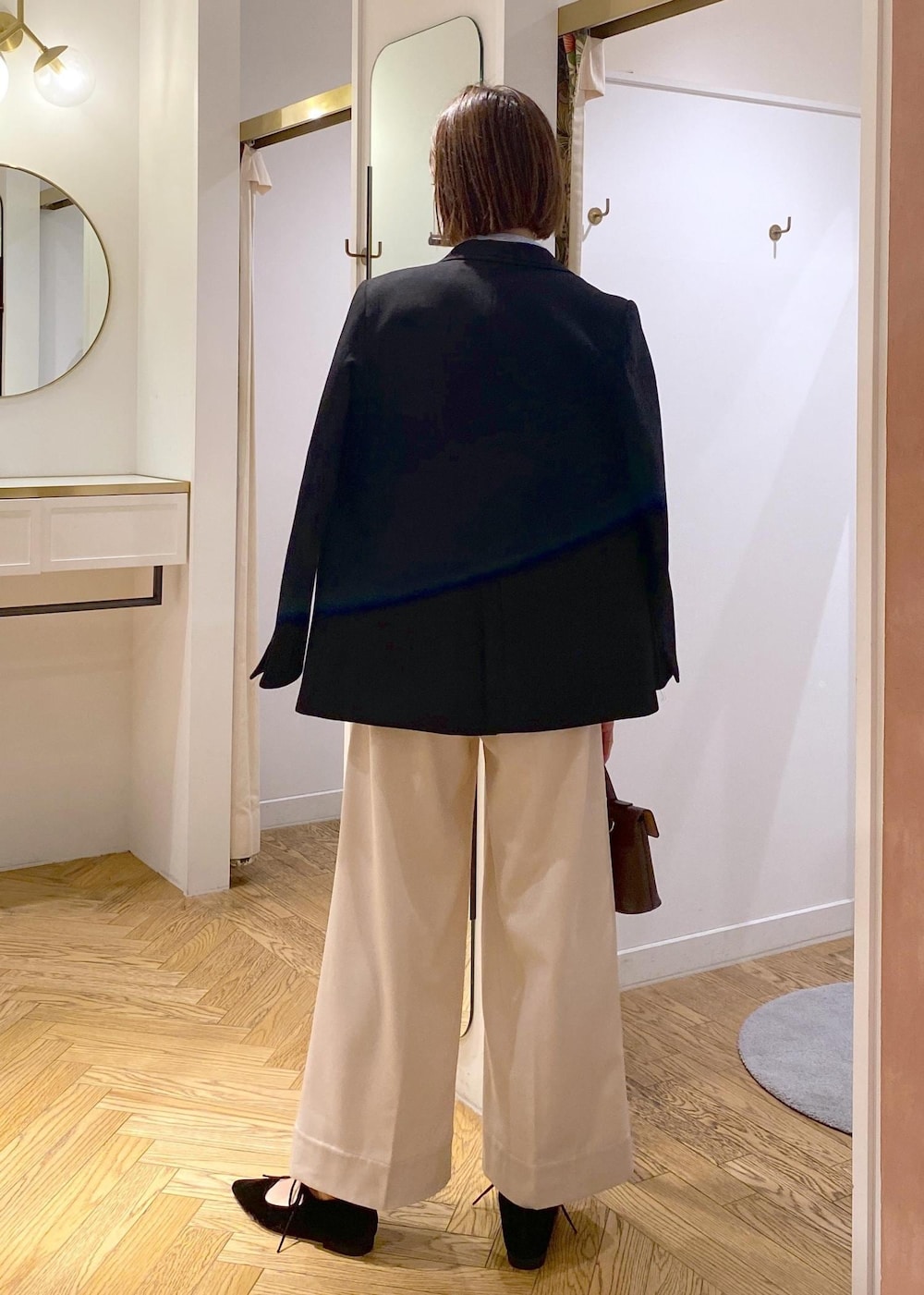 ブラウン系のショルダーバッグ、ブラック系のテーラードジャケット、ブルー系のシャツ/ブラウスを着用したレディースの冬コーディネートの3枚目の写真