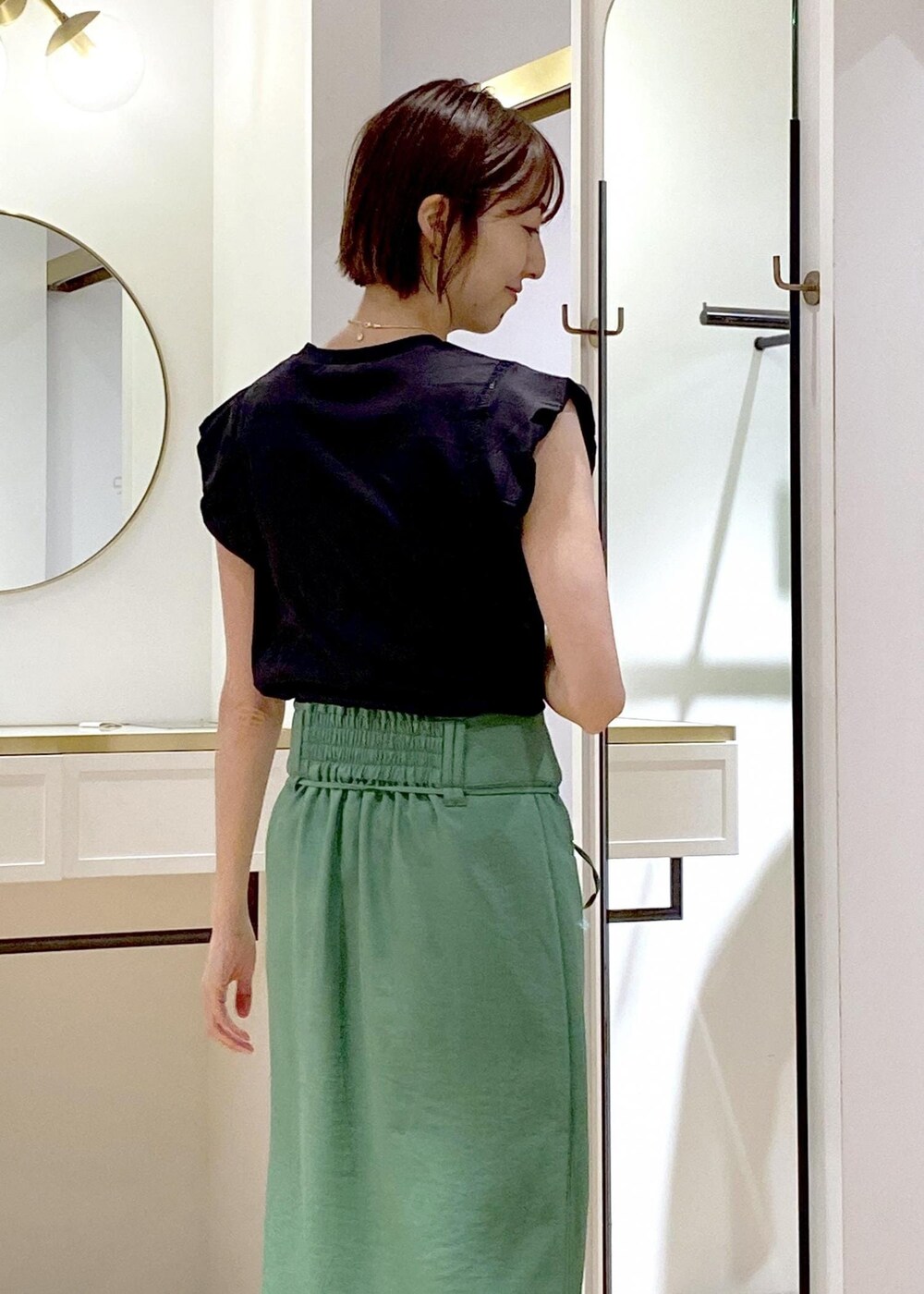 ブラック系のショルダーバッグ、ブラック系のサンダル、ホワイト系のカーディガン/ボレロを着用したレディースの夏コーディネートの5枚目の写真