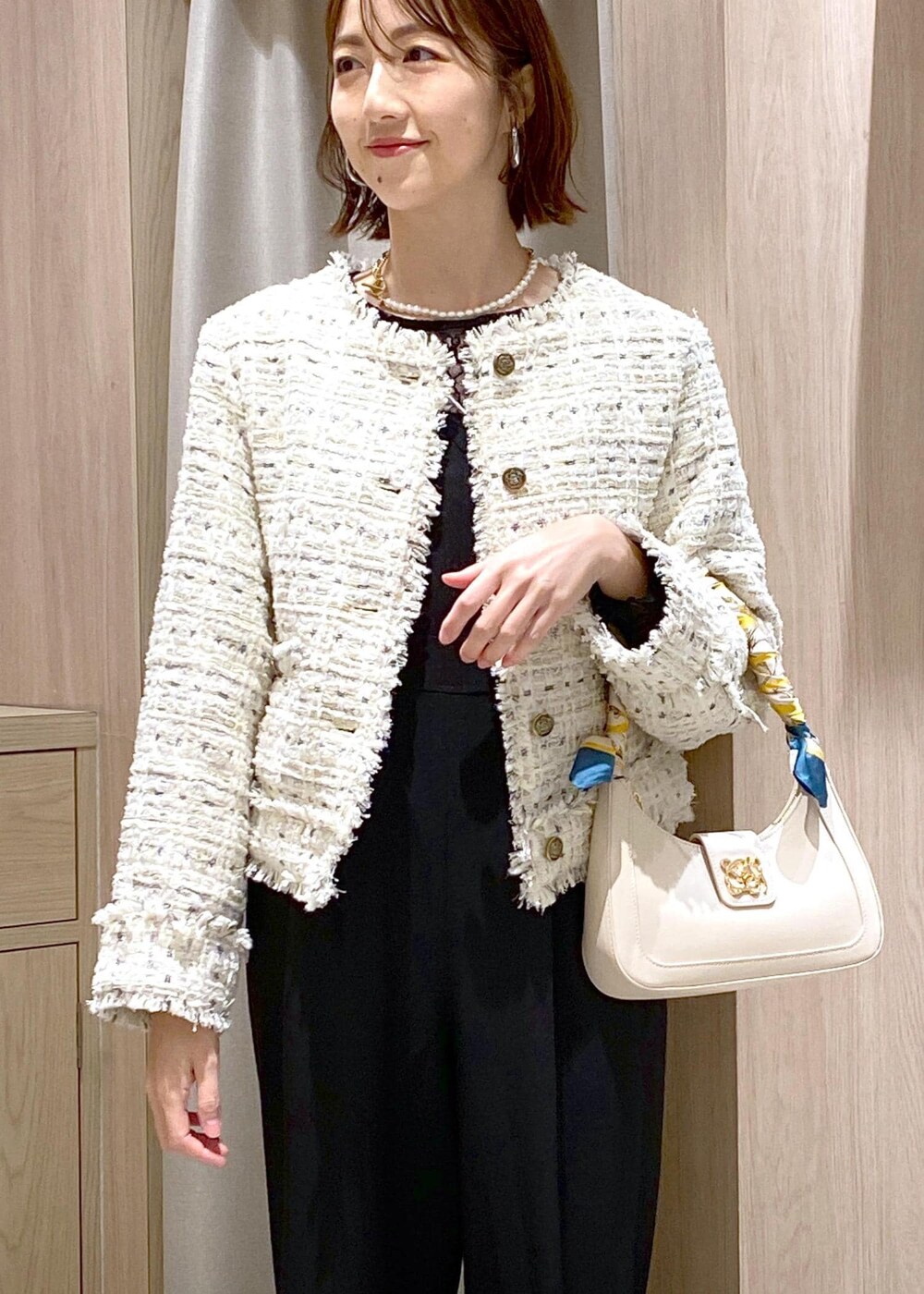 ホワイト系のハンドバッグ、シルバー系のパンプス、ブラック系のTシャツ/カットソーを着用したレディースの冬コーディネートの7枚目の写真