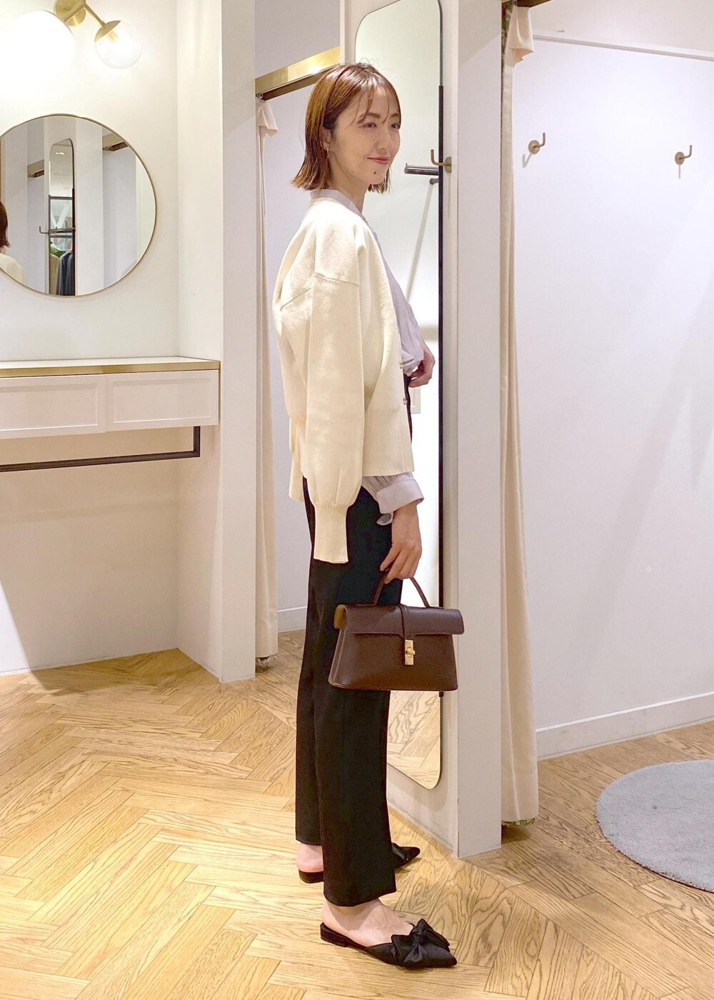 ブラウン系のショルダーバッグ、ブラック系のサンダル、ブラック系のスラックスを着用したレディースの秋コーディネートの2枚目の写真