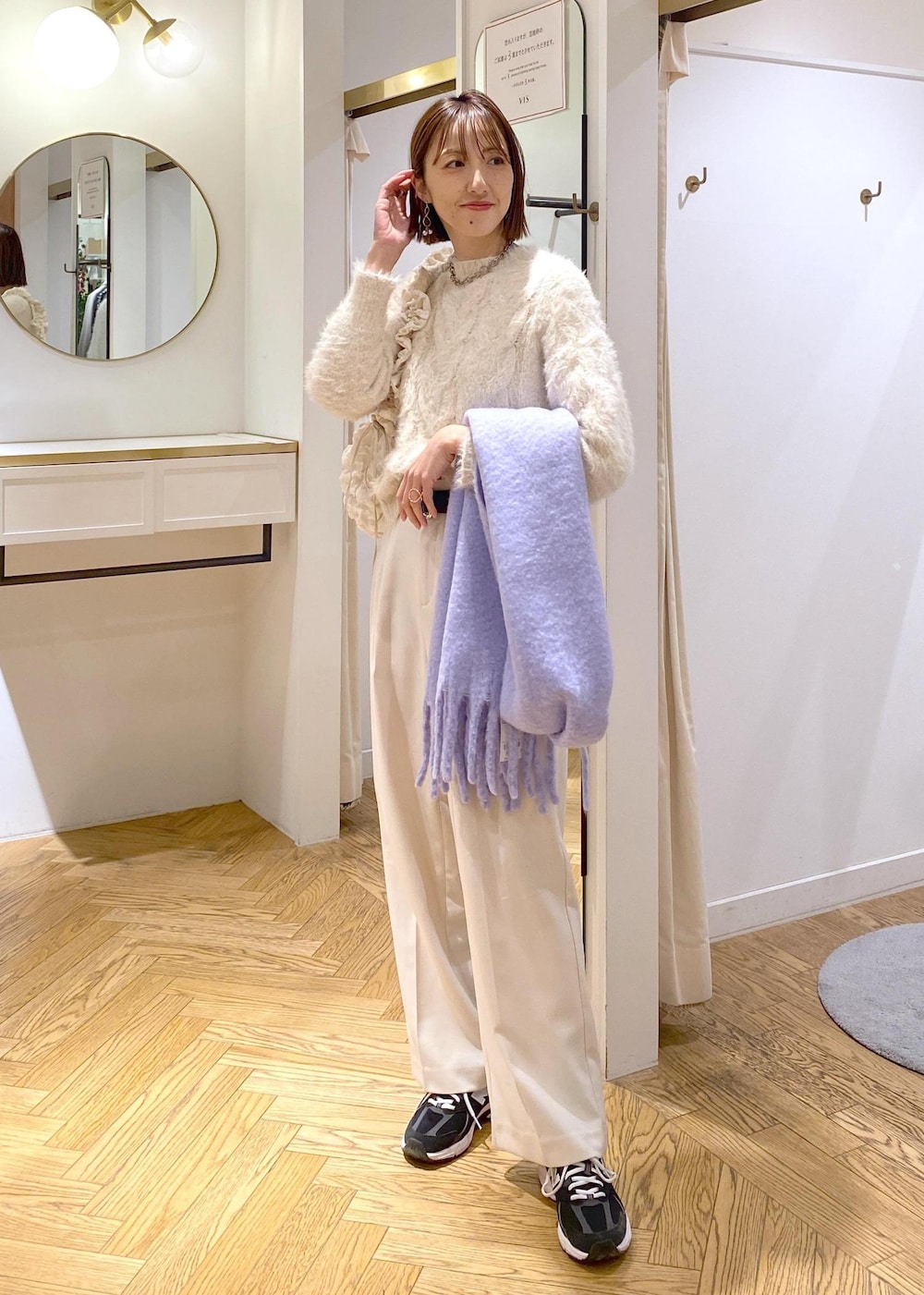 ベージュ系のニット/セーター、ホワイト系のスラックス、ホワイト系のショルダーバッグを着用したレディースの冬コーディネートの6枚目の写真