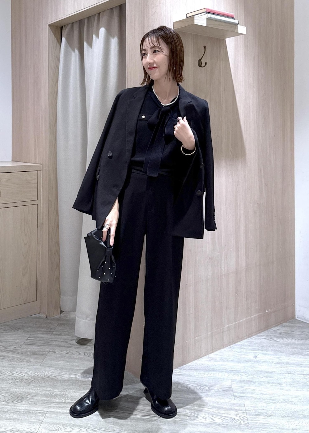 ブラック系のスラックス、ブラック系のテーラードジャケット、ブラック系のショルダーバッグを着用したレディースの冬コーディネートの5枚目の写真