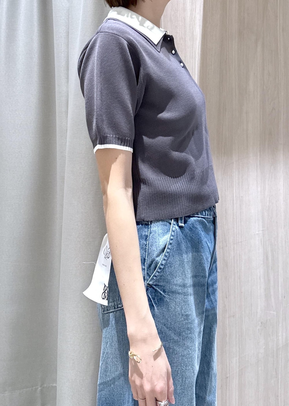 ホワイト系のキャミソール、ブラック系のトートバッグ、ブルー系のデニムパンツを着用したレディースの春コーディネートの8枚目の写真