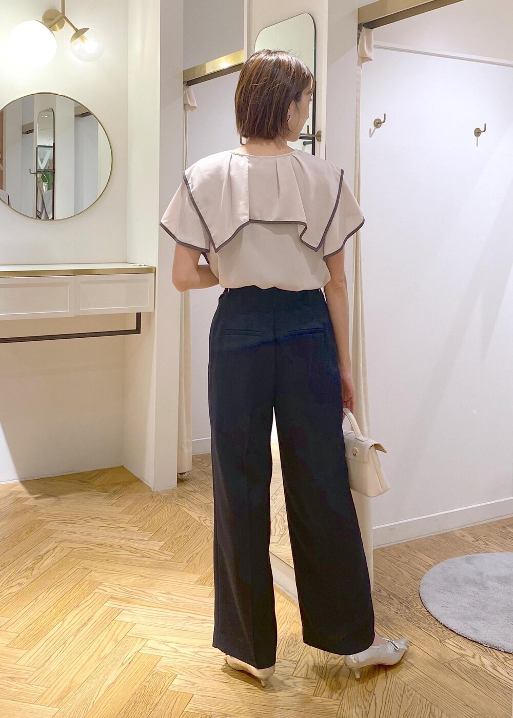 シルバー系のパンプス、ブラック系のキャミソール、ブルー系のスラックスを着用したレディースの夏コーディネートの3枚目の写真