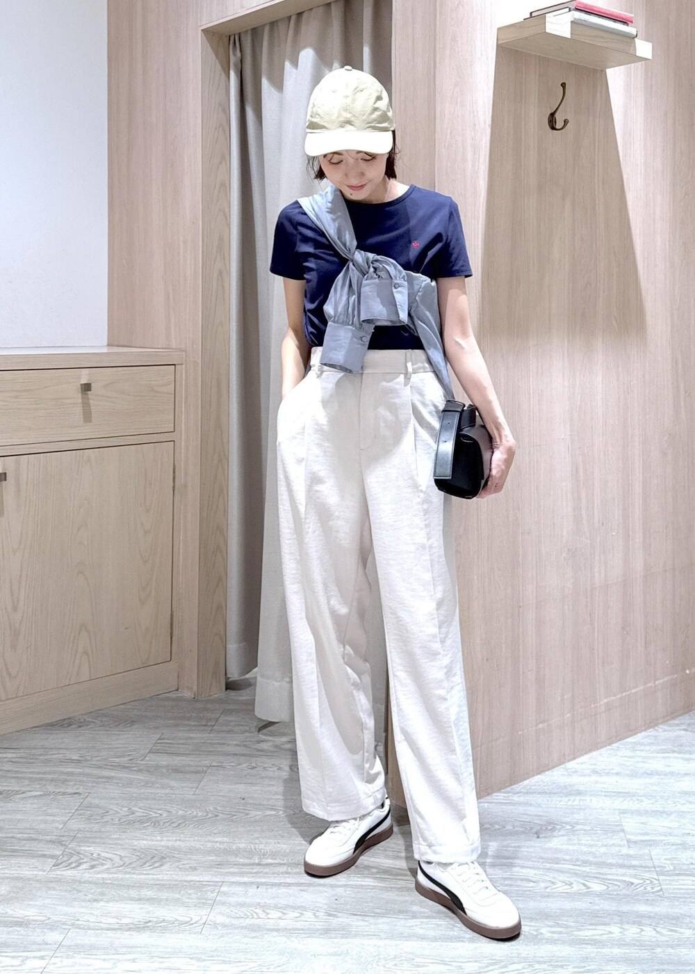 ブラック系のショルダーバッグ、グレー系のシャツ/ブラウス、ホワイト系のスラックスを着用したレディースの春コーディネートの4枚目の写真