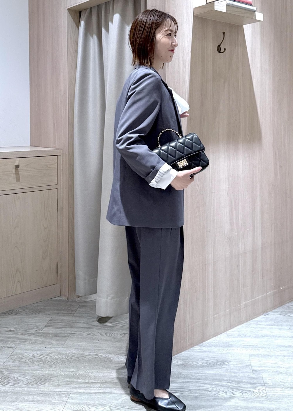 ブラック系のショルダーバッグ、グレー系のその他パンツ、グレー系のテーラードジャケットを着用したレディースの冬コーディネートの2枚目の写真