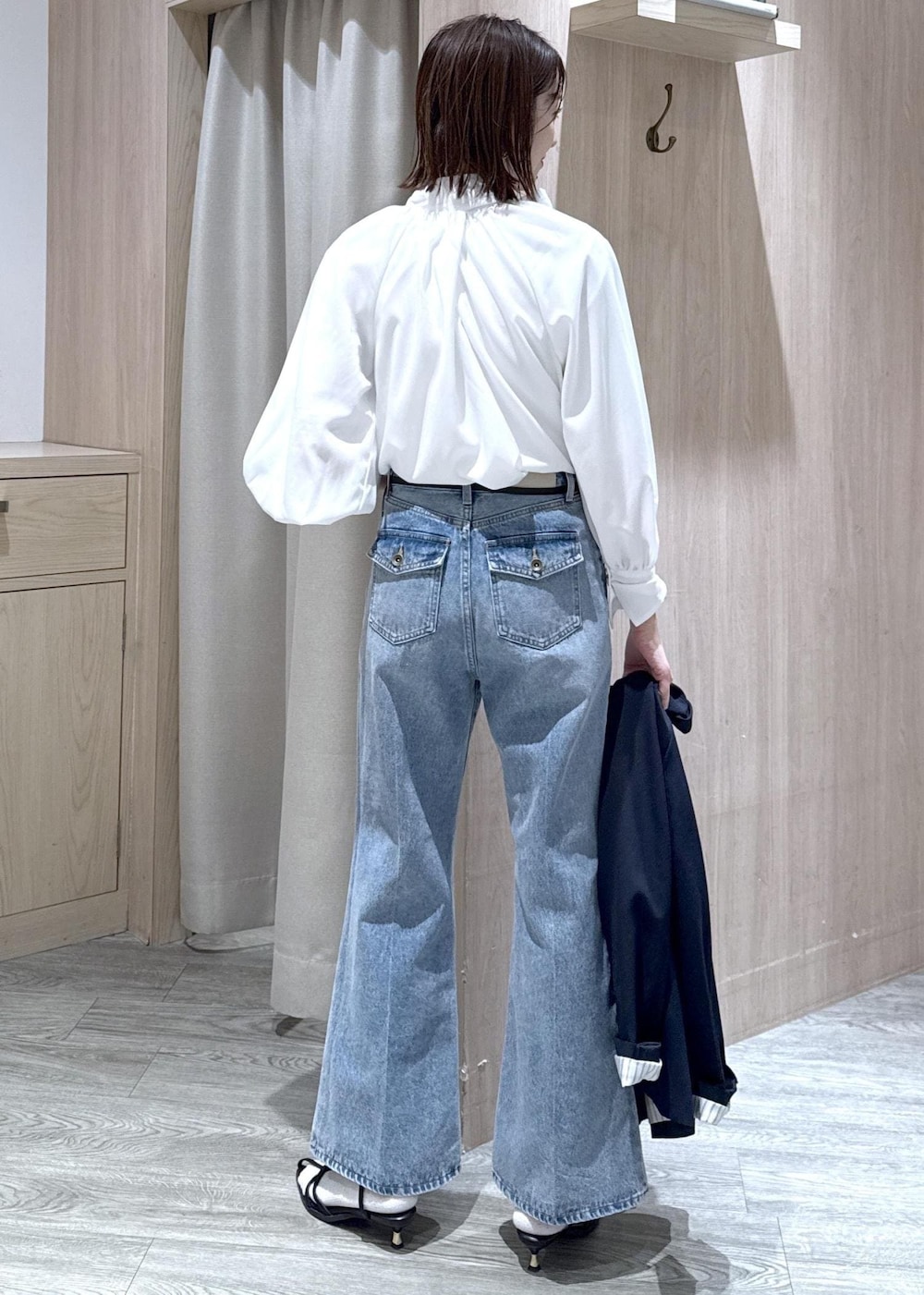 ブルー系のテーラードジャケット、ブラック系のショルダーバッグ、ブルー系のデニムパンツを着用したレディースの冬コーディネートの7枚目の写真