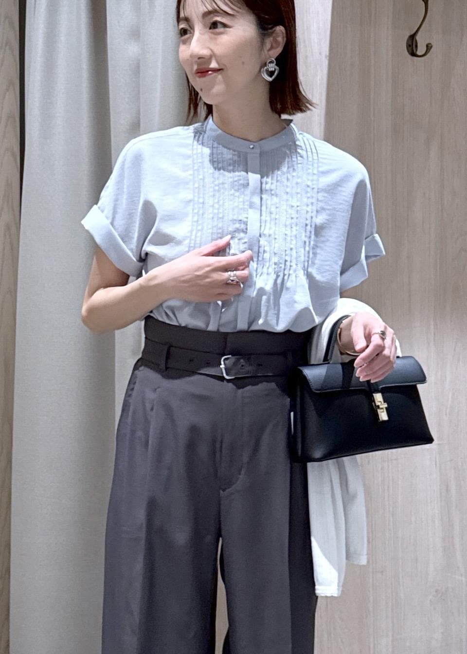 ブラック系のショルダーバッグ、ブラック系のパンプス、ブルー系のシャツ/ブラウスを着用したレディースの夏コーディネートの4枚目の写真