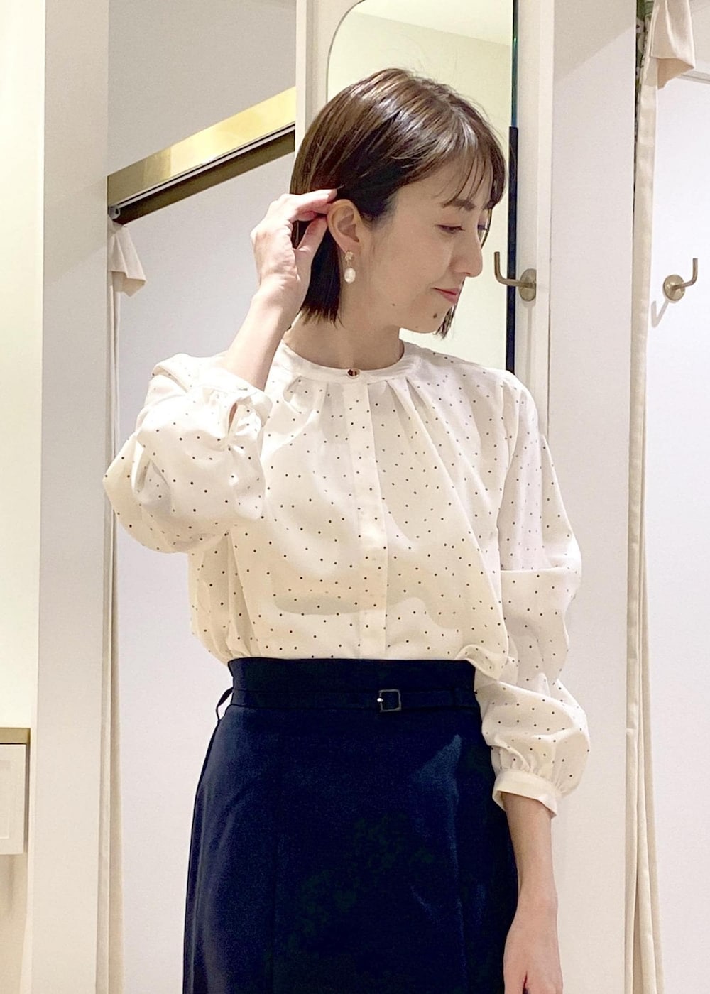 ホワイト系のパンプス、ブラック系のボストンバッグ、ホワイト系のシャツ/ブラウスを着用したレディースの春コーディネートの4枚目の写真