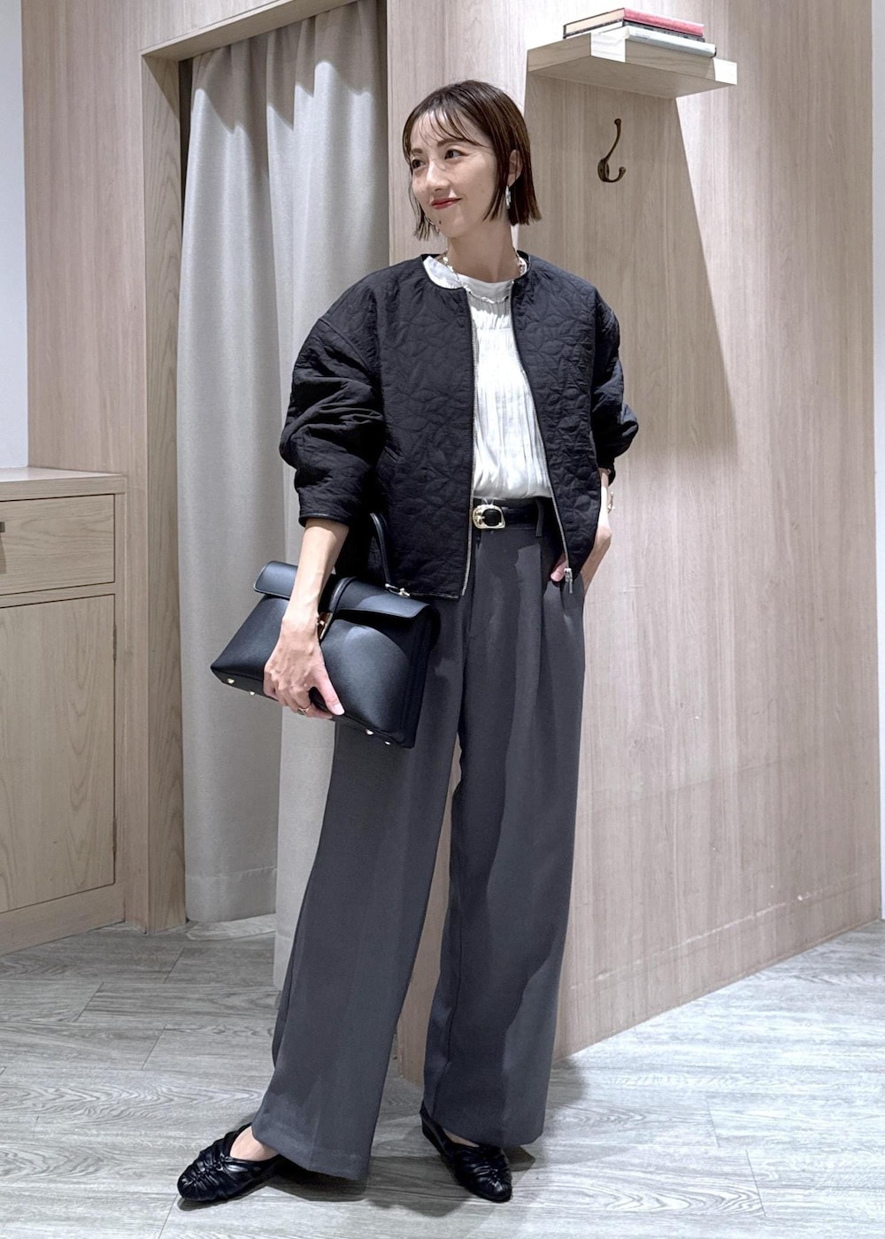 ブラック系のハンドバッグ、グレー系のスラックス、ホワイト系のシャツ/ブラウスを着用したレディースの秋コーディネートの10枚目の写真