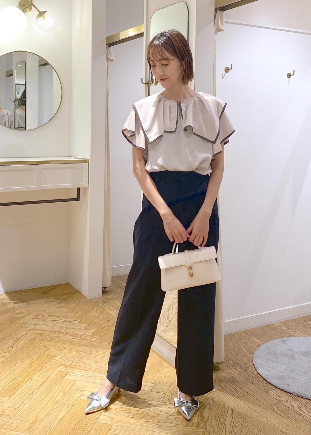 シルバー系のパンプス、ブラック系のキャミソール、ブルー系のスラックスを着用したレディースの夏コーディネートの2枚目の写真