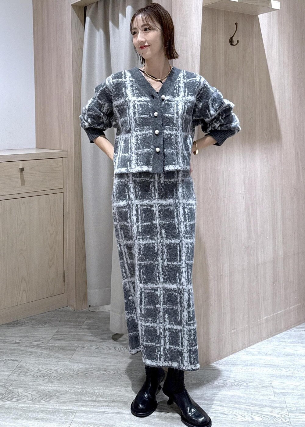 レッド系のボストンバッグ、ブラック系のダウンジャケット/コート、グレー系のスカートを着用したレディースの冬コーディネートの8枚目の写真