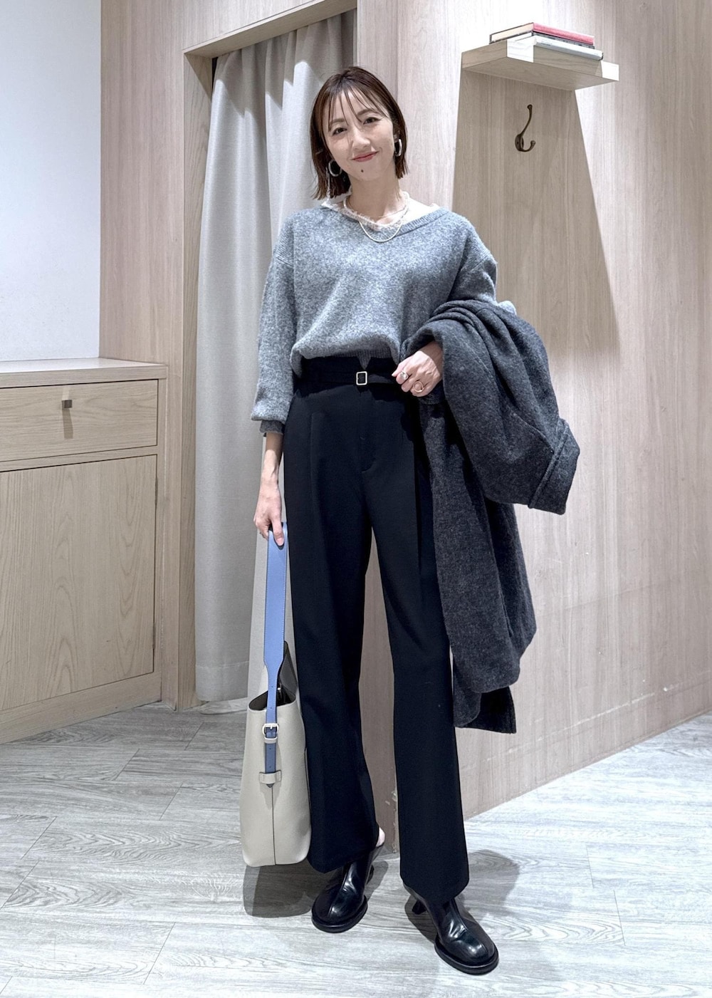 グレー系のニット/セーター、グレー系のその他アウター、ブラック系のその他パンツを着用したレディースの冬コーディネートの2枚目の写真