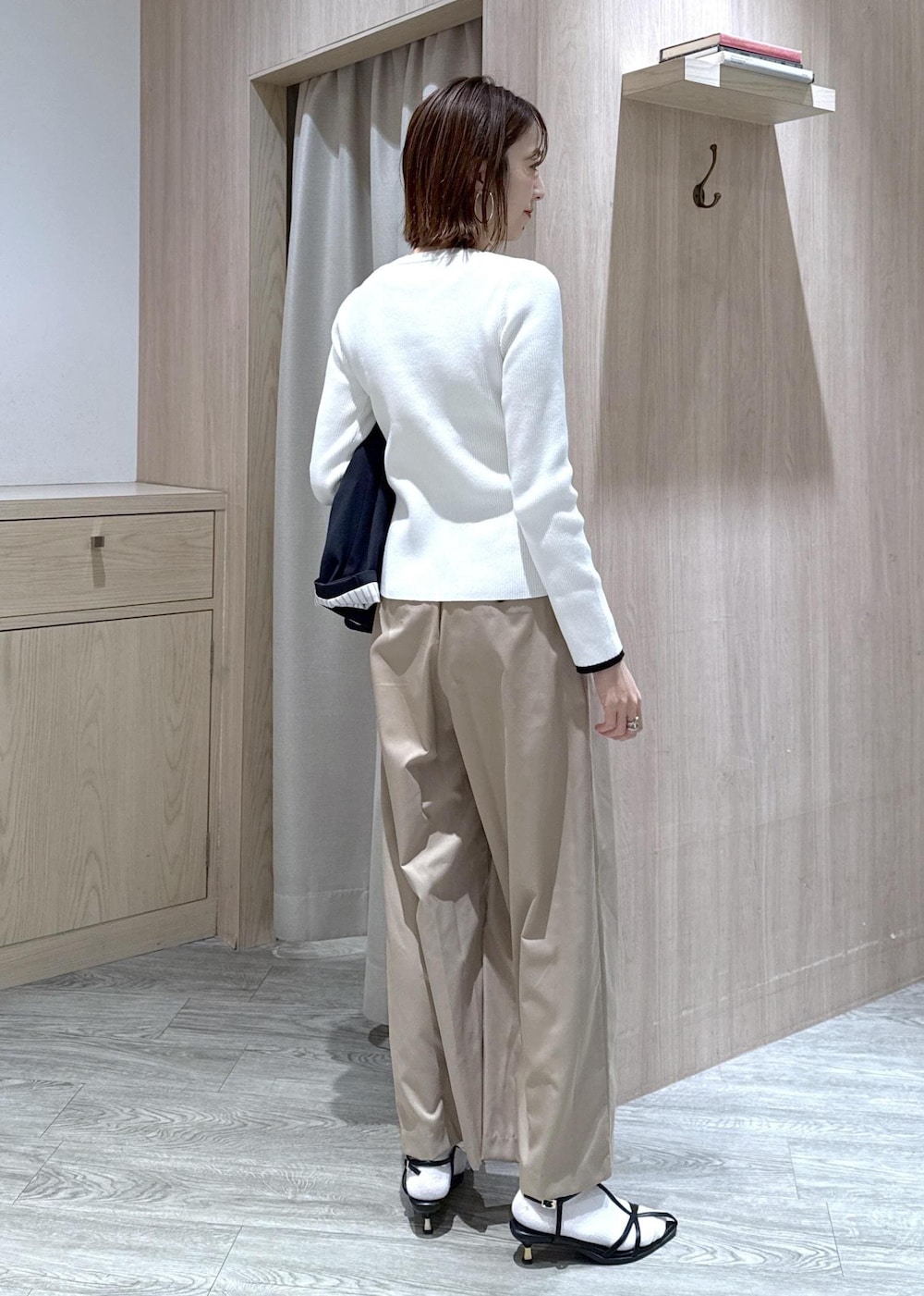 ブルー系のテーラードジャケット、ブラック系のトートバッグ、ホワイト系のカーディガン/ボレロを着用したレディースの冬コーディネートの8枚目の写真