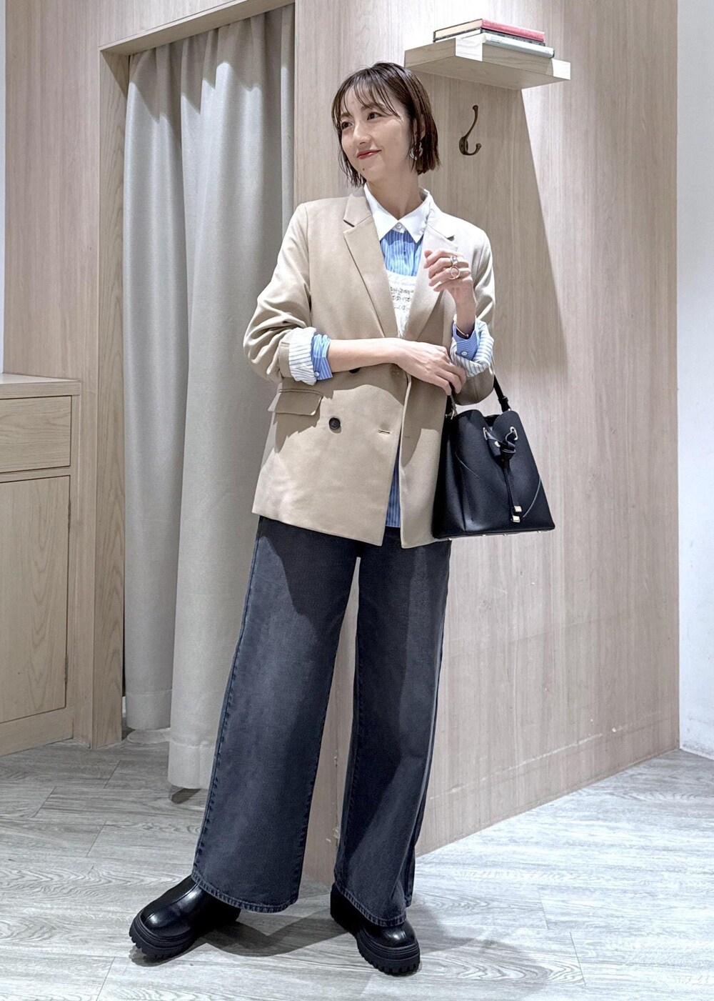 ブラック系のショルダーバッグ、ベージュ系のテーラードジャケット、ブラック系のブーツを着用したレディースの秋コーディネートの10枚目の写真