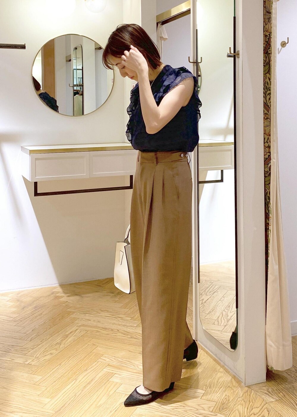 ブラック系のパンプス、ホワイト系のキャミソール、ホワイト系のハンドバッグを着用したレディースの春コーディネートの3枚目の写真