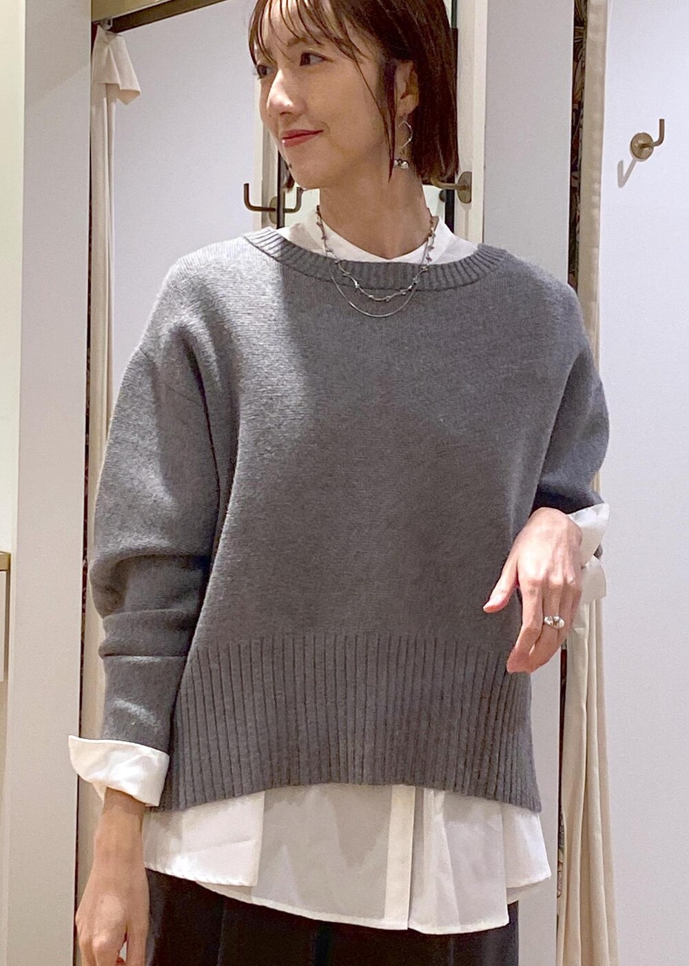 ブラック系のブーツ、ホワイト系のシャツ/ブラウス、グレー系のニット/セーターを着用したレディースの冬コーディネートの7枚目の写真