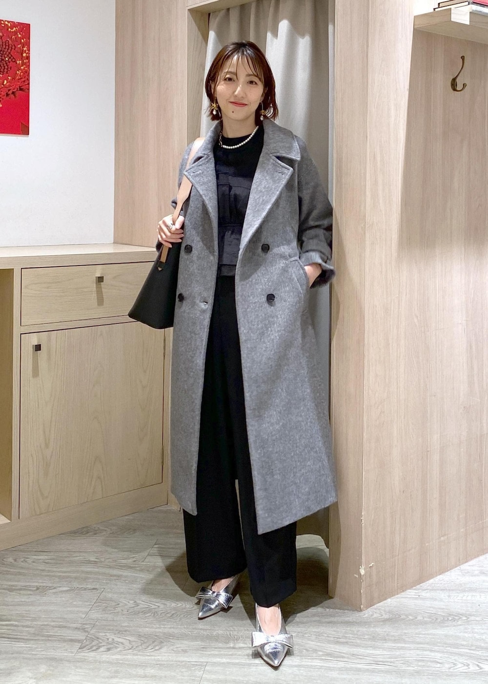 シルバー系のパンプス、ブラック系のスラックス、ブラック系のニット/セーターを着用したレディースの冬コーディネートの2枚目の写真