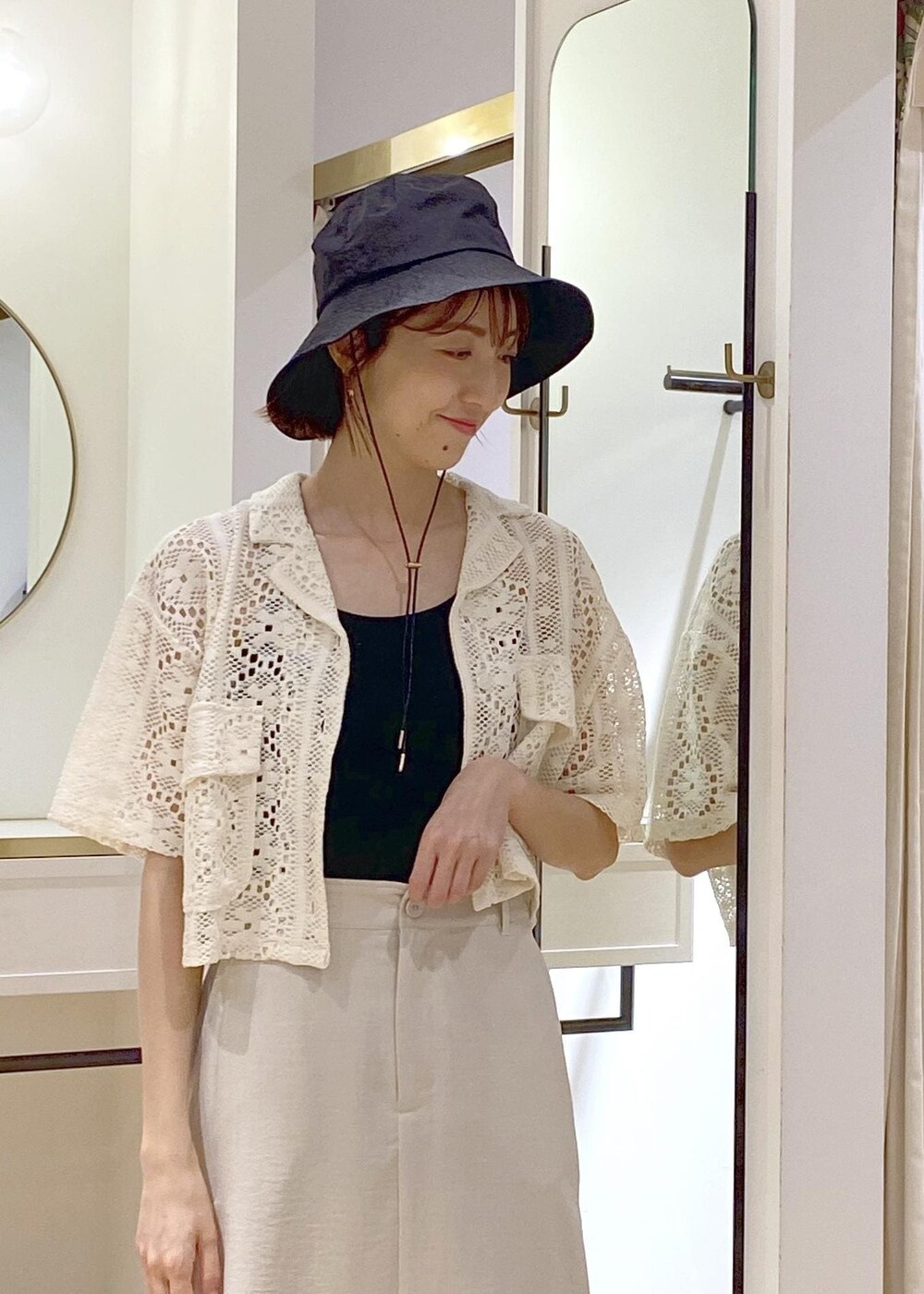 ブラック系のキャミソール、ブラック系のサンダル、ゴールド系のトートバッグを着用したレディースの春コーディネートの4枚目の写真