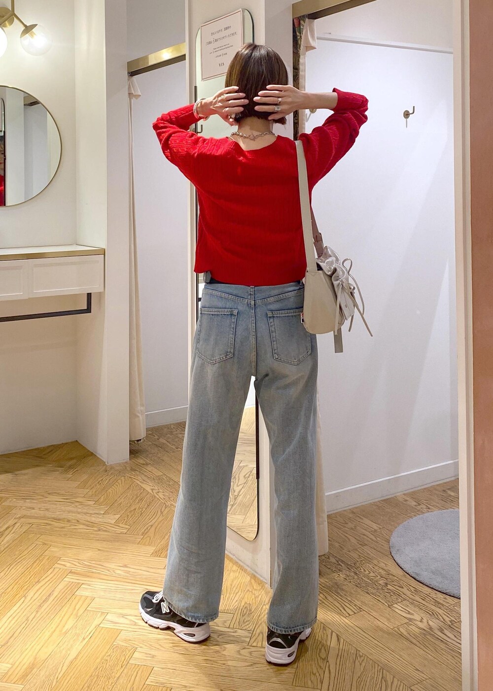 レッド系のニット/セーター、ブルー系のデニムパンツ、ブラック系のベルトを着用したレディースの冬コーディネートの4枚目の写真