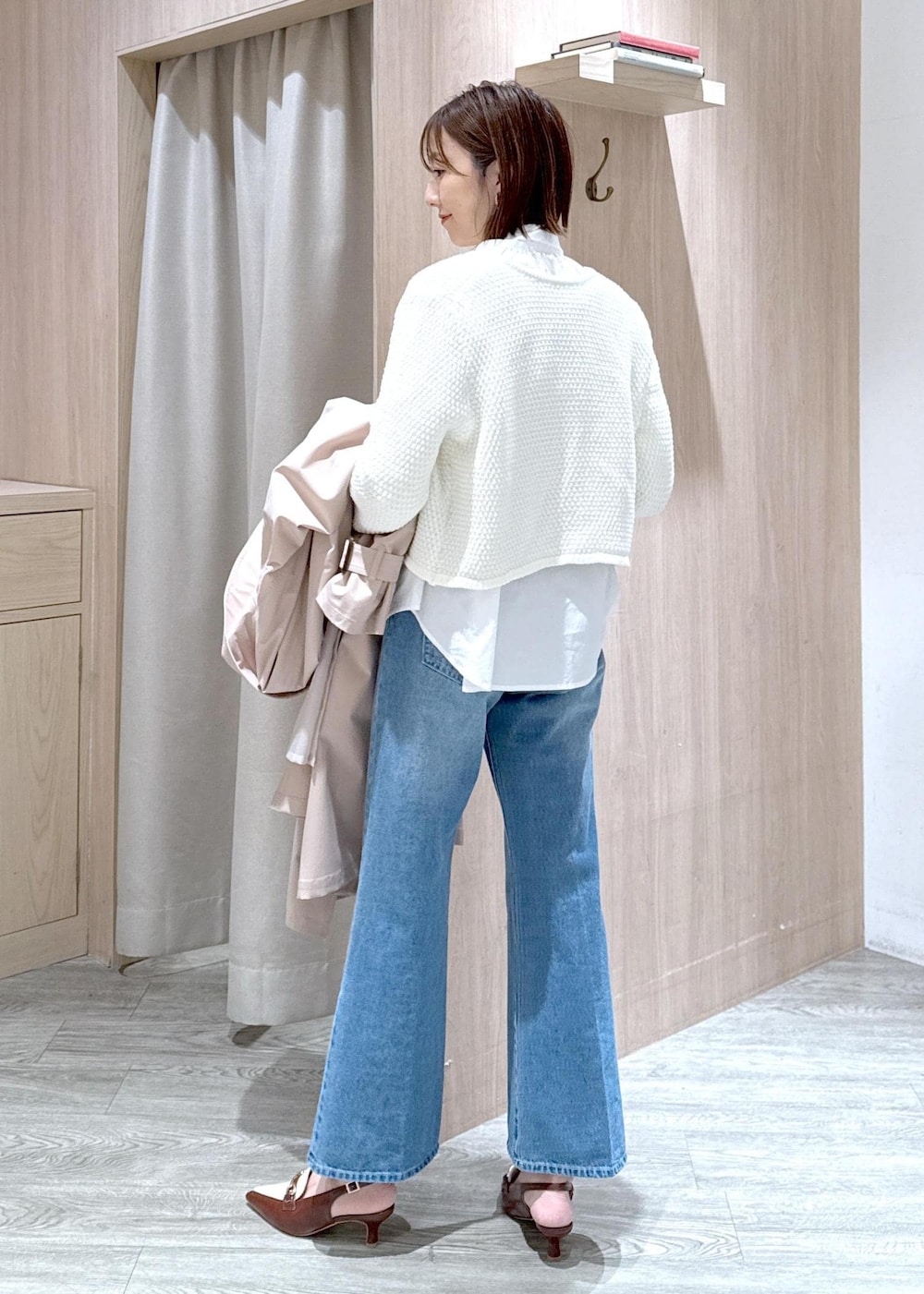 ブラック系のショルダーバッグ、ベージュ系のトレンチコート、ホワイト系のカーディガン/ボレロを着用したレディースの春コーディネートの7枚目の写真