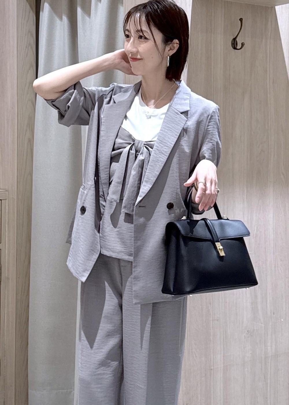 ブラック系のハンドバッグ、ブラック系のパンプス、グレー系のTシャツ/カットソーを着用したレディースの春コーディネートの4枚目の写真