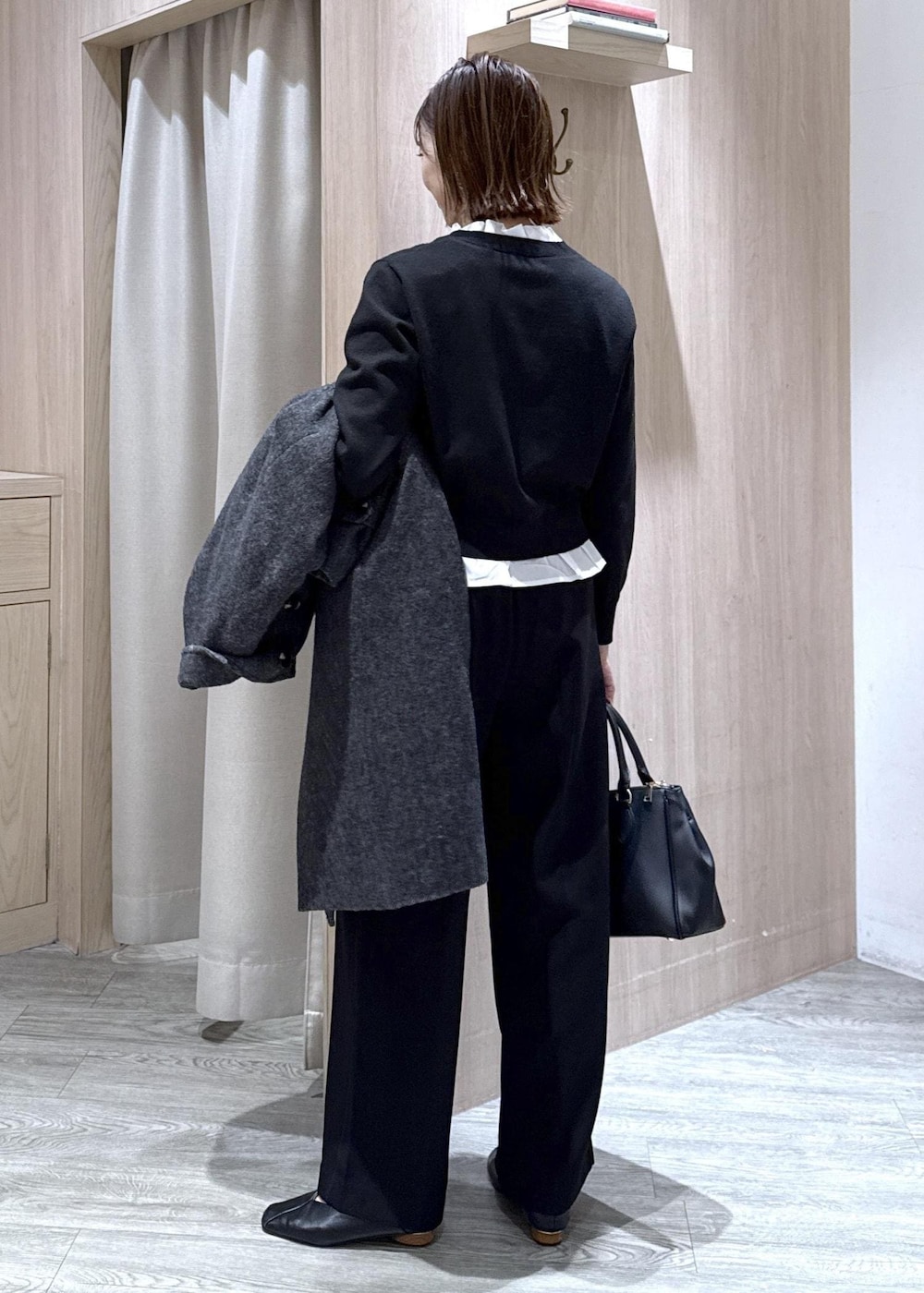 ブラック系のショルダーバッグ、ブラック系のスラックス、グレー系のその他アウターを着用したレディースの冬コーディネートの3枚目の写真