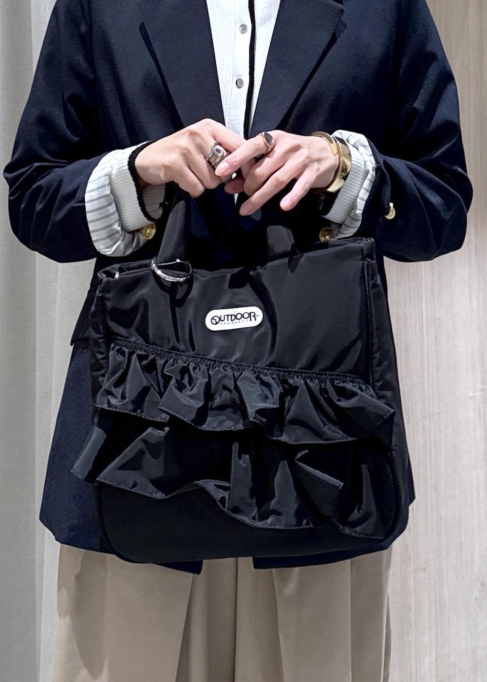 ブルー系のテーラードジャケット、ブラック系のトートバッグ、ホワイト系のカーディガン/ボレロを着用したレディースの冬コーディネートの5枚目の写真