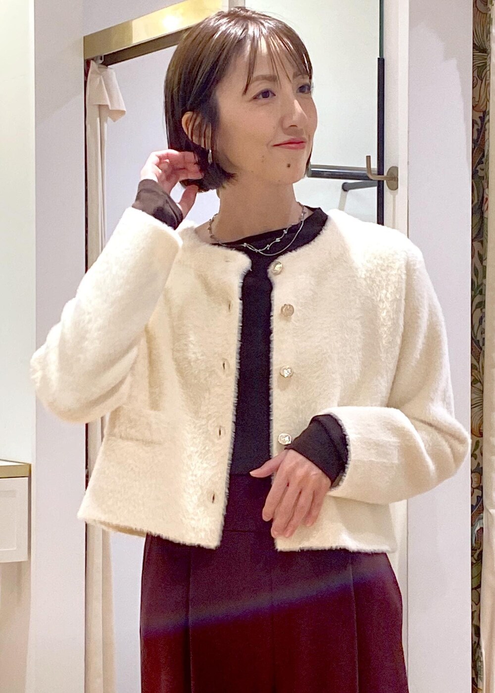 ホワイト系のハンドバッグ、ブラック系のパンプス、ブラウン系のその他パンツを着用したレディースの冬コーディネートの6枚目の写真