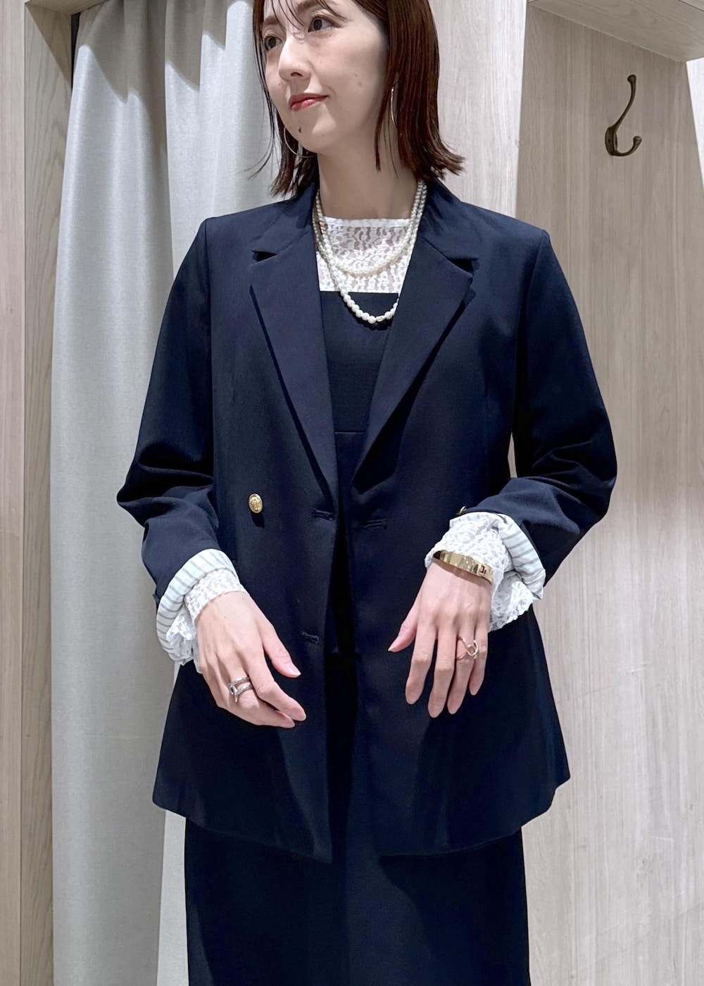 ブラック系のパンプス、ブルー系のテーラードジャケット、ブルー系のワンピースを着用したレディースの冬コーディネートの5枚目の写真