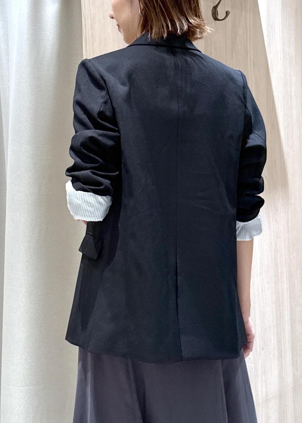 ブラック系のパンプス、ブラック系のテーラードジャケット、ベージュ系のショルダーバッグを着用したレディースの秋コーディネートの9枚目の写真