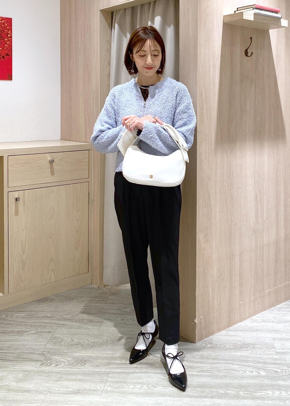 ブラック系のパンプス、ブルー系のカーディガン/ボレロ、ブラック系のTシャツ/カットソーを着用したレディースの冬コーディネートの3枚目の写真