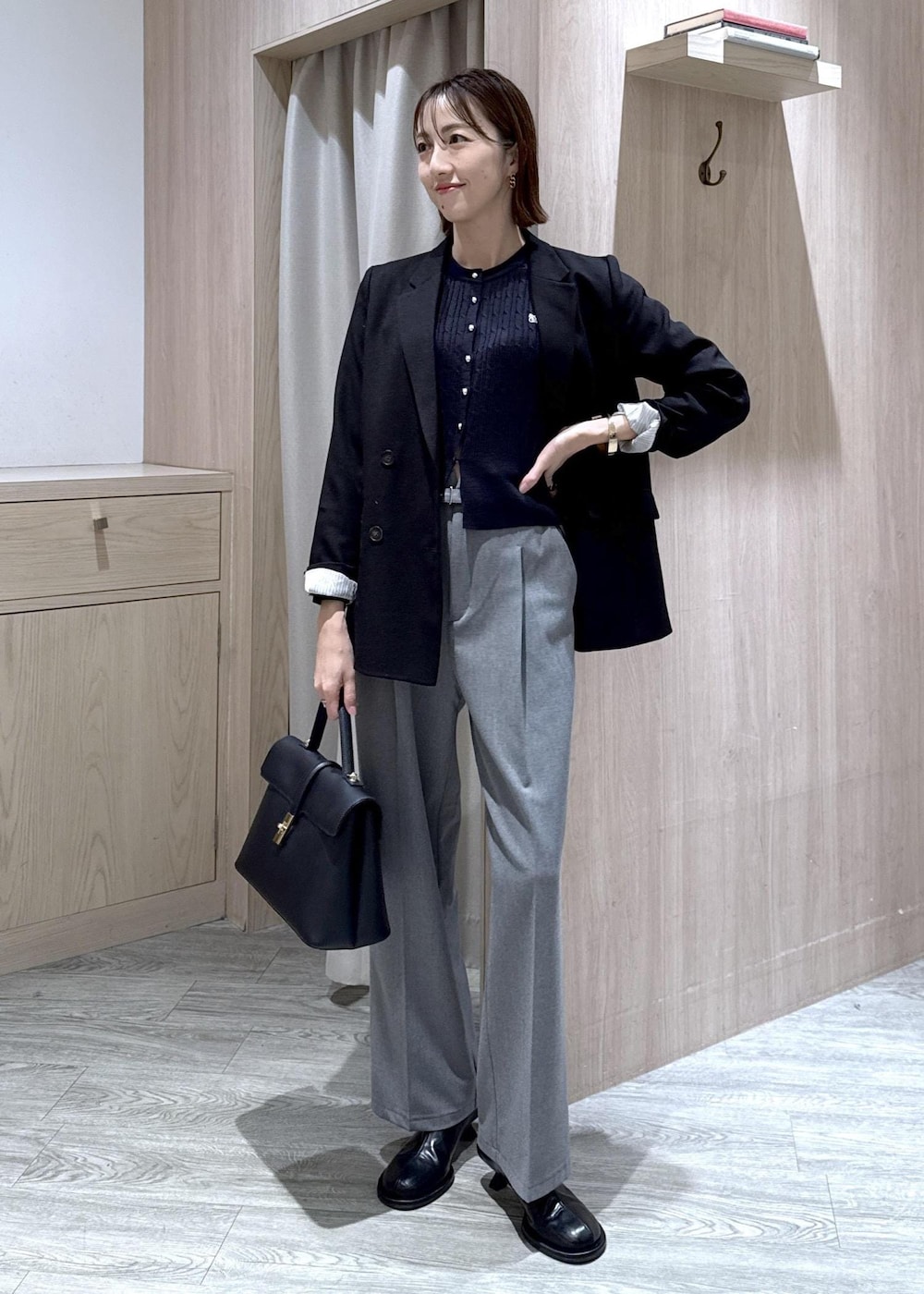 ブラック系のハンドバッグ、ブラック系のテーラードジャケット、グレー系のその他パンツを着用したレディースの冬コーディネートの7枚目の写真