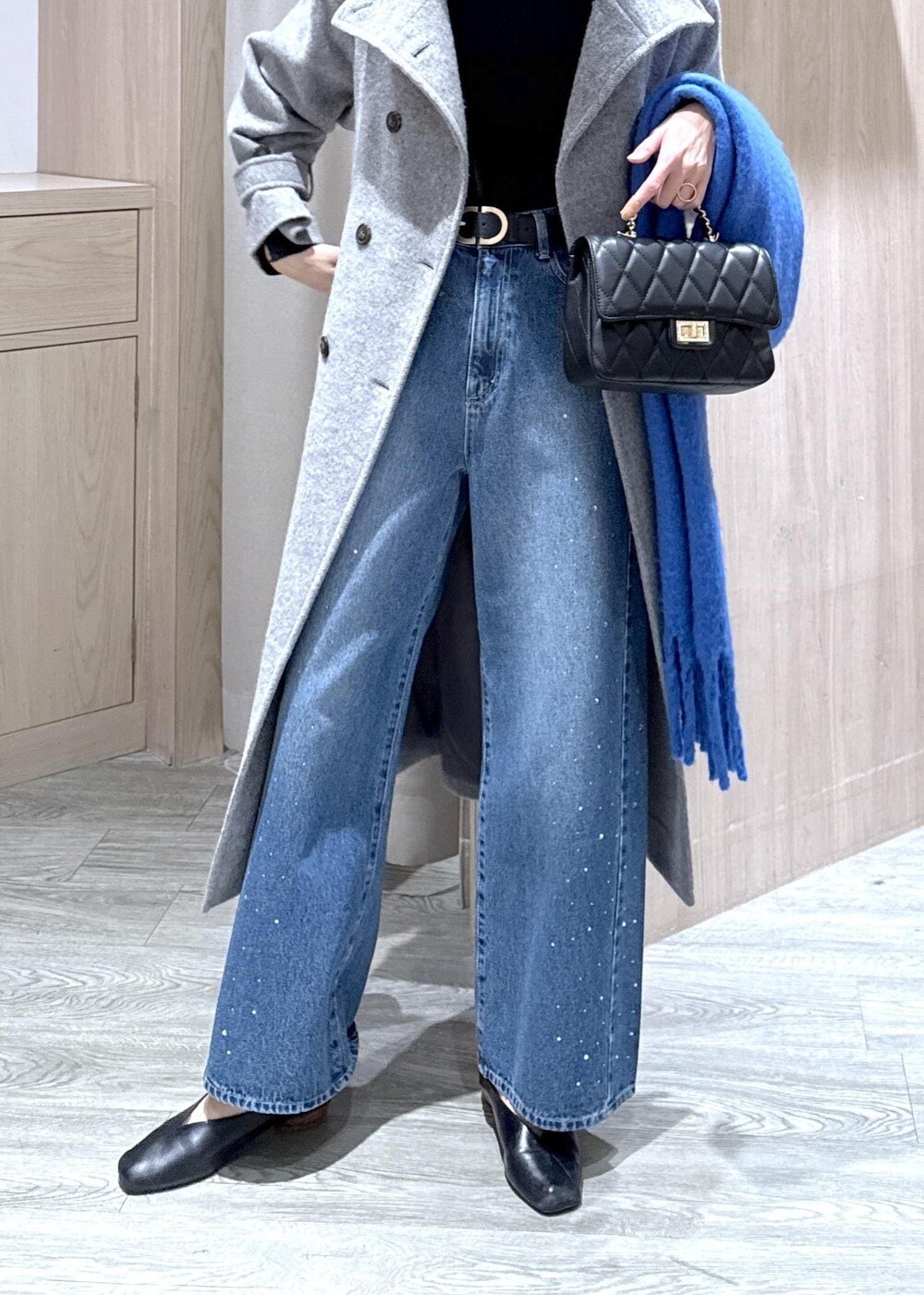 グレー系のその他アウター、ブルー系のデニムパンツ、ブラック系のニット/セーターを着用したレディースの冬コーディネートの4枚目の写真