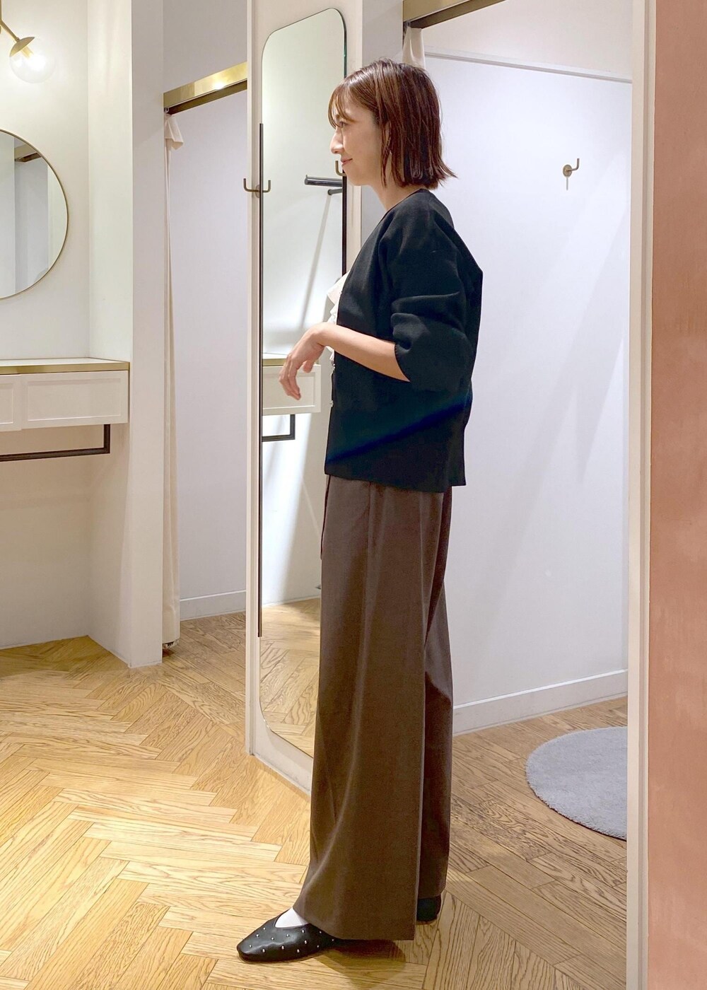 ホワイト系のシャツ/ブラウス、ブラック系のバレエシューズ、ブラック系のカーディガン/ボレロを着用したレディースの秋コーディネートの2枚目の写真