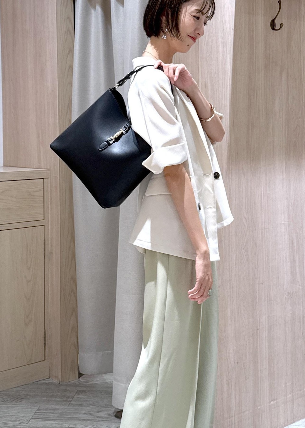 ベージュ系のキャミソール、ブラック系のサンダル、ブラック系のトートバッグを着用したレディースの夏コーディネートの7枚目の写真