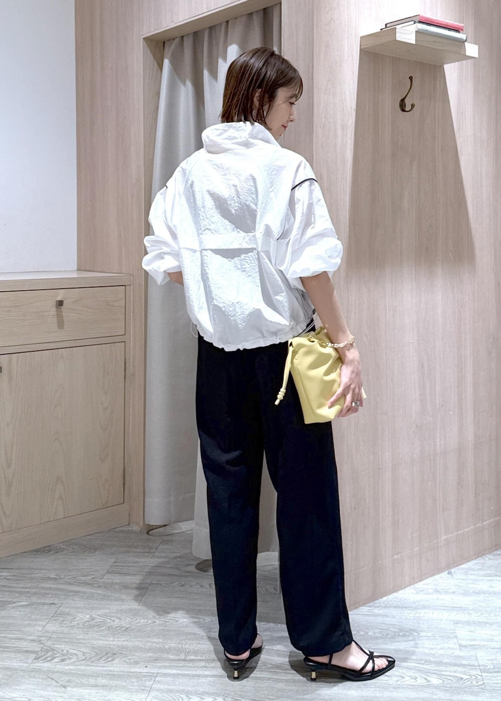 グレー系のタンクトップ、ブラック系のサンダル、ブラック系のスラックスを着用したレディースの春コーディネートの3枚目の写真