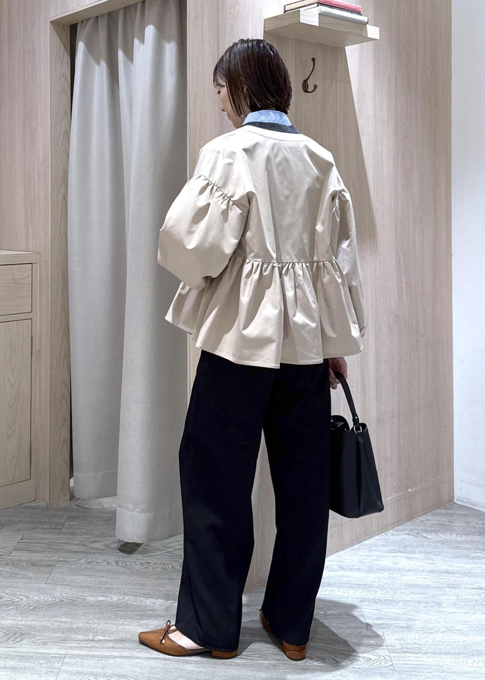 ブラック系のショルダーバッグ、イエロー系のパンプス、ベージュ系のブルゾンを着用したレディースの秋コーディネートの3枚目の写真