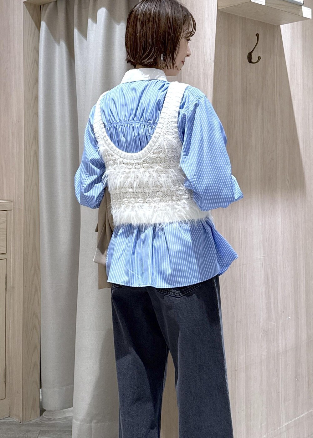 ブラック系のショルダーバッグ、ベージュ系のテーラードジャケット、ブラック系のブーツを着用したレディースの秋コーディネートの9枚目の写真